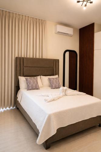 a bedroom with a large bed with white sheets and pillows at Skylight Suites Hotel in San Felipe de Puerto Plata