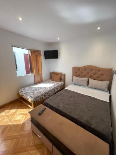 a room with two beds and a flat screen tv at Hospedaje vista del sur paracas in Paracas