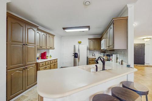 a kitchen with wooden cabinets and a white counter top at <1 Block to Trails! Conway Biker & Hikers Haven in Conway