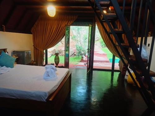 a bedroom with a bed and a large window at Dambulla Tiger Rock Hotel with Mountain Viewpoint in Dambulla