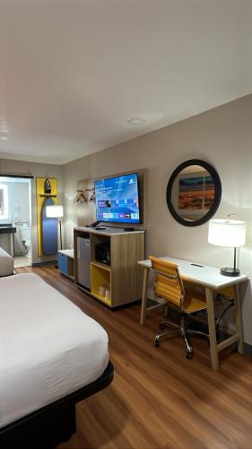 a hotel room with a bed and a desk and a tv at Days Inn by Wyndham Payson in Payson