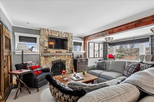 a living room with a couch and a fireplace at Stowestruck in Stowe