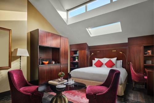 a bedroom with a bed and a table and chairs at The Vagabond Club, a Tribute Portfolio Hotel Singapore in Singapore