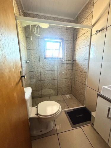 a small bathroom with a toilet and a shower at Apto na Praia do Cassino in Rio Grande