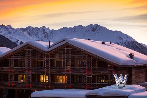 Eine Berghütte mit Schnee auf dem Dach in der Unterkunft W Verbier in Verbier