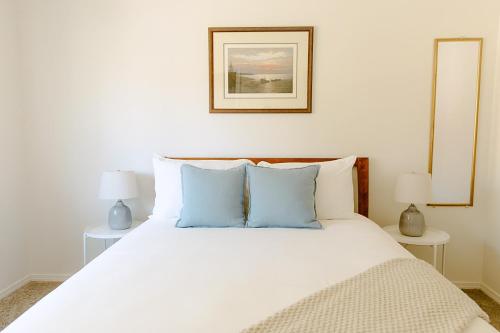 a bedroom with a large white bed with blue pillows at The Lighthouse in Moscow