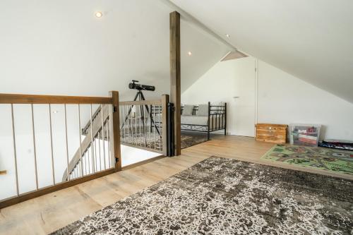 an attic room with a staircase and a rug at Haus Weitwinkel in Sehestedt