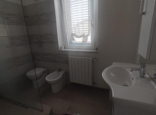 a bathroom with a sink and a toilet and a window at Sweet Home in Corbetta