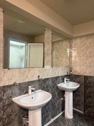 a bathroom with two sinks and a mirror at Time Stay Hotel in Yerevan