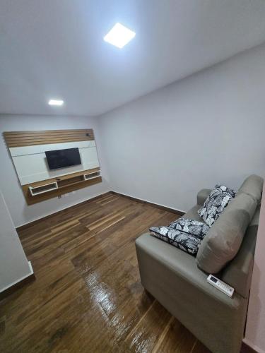 a living room with a couch and a flat screen tv at Apartamento quarto e sala em campo grande in Cariacica