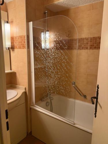 a bathroom with a shower and a tub and a sink at Apparthotel Saint Tropez centre in Saint-Tropez