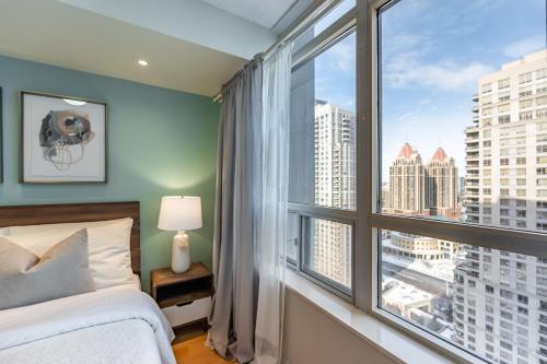 a bedroom with a bed and a large window at Designer Apartment in Prime Location in Mississauga