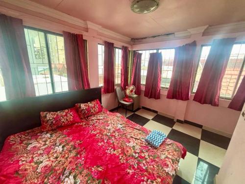 a bedroom with a bed and a chair and windows at Arecrata in Phnom Penh