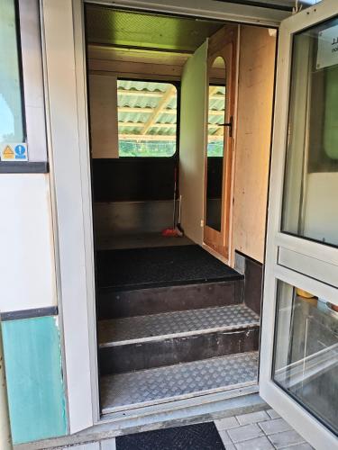 an open door of an empty train car with stairs at Glampingbus in Kärdla