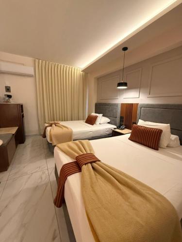 a hotel room with three beds in a room at Hotel Residencial in Mérida