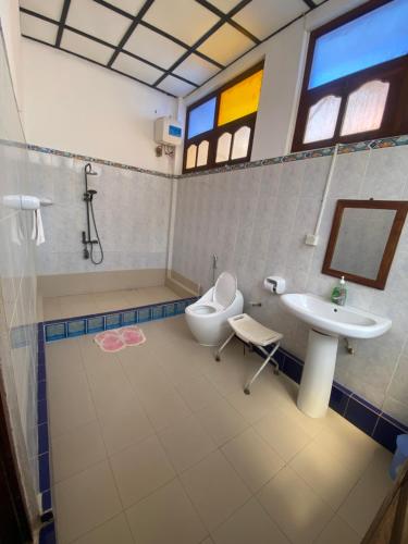 a bathroom with a sink and a toilet and a mirror at Tonys homestay in Zanzibar City