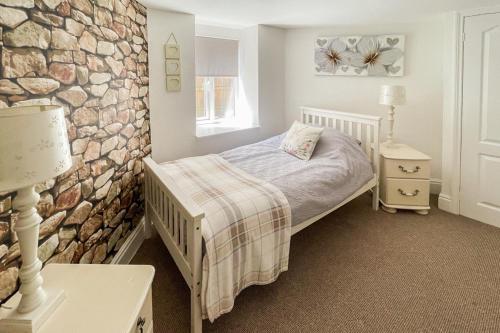 a bedroom with a bed and a stone wall at 3 Bed in Ventnor oc-89972 in Niton