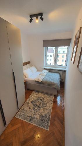 a small room with a bed and a window at Apartament Witosa in Tarnów