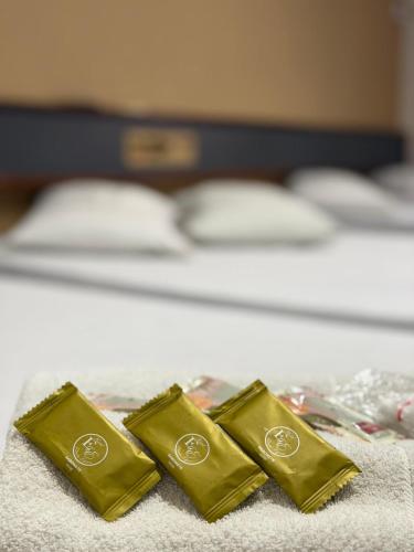 two gold containers sitting on top of a bed at Hotel Estação Express in Curitiba