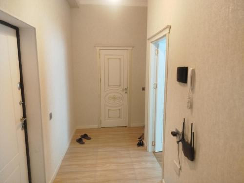 a hallway with a white door and shoes on the floor at sumqayit bulvari deniz kenari in Sumqayıt