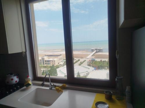 a kitchen sink and a window with a view of the beach at sumqayit bulvari deniz kenari in Sumqayıt
