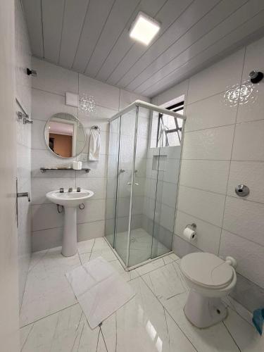 a bathroom with a shower and a toilet and a sink at Hotel Estação Express in Curitiba