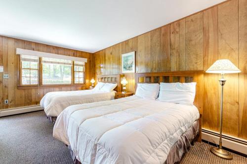 two beds in a room with wooden walls at King Birch Lake Home, Unit 3 in Alton
