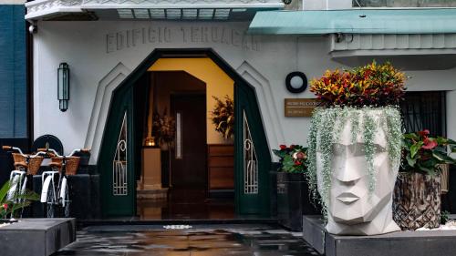 eine Eingangstür eines Gebäudes mit Blumen und einem Gesicht in der Unterkunft Hippodrome Hotel in Mexiko-Stadt