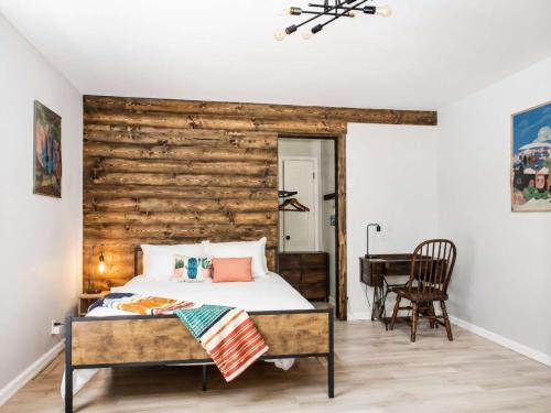 a bedroom with a bed and a wooden wall at The PanAm fire pit bbq kid & dog friendly in Pensacola