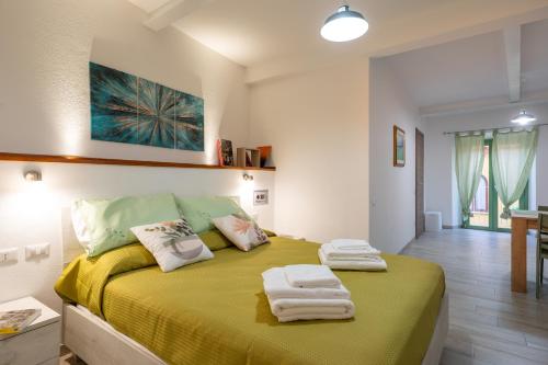 a bedroom with a green bed with towels on it at Raggio di Sole Ulassai in Ulassai