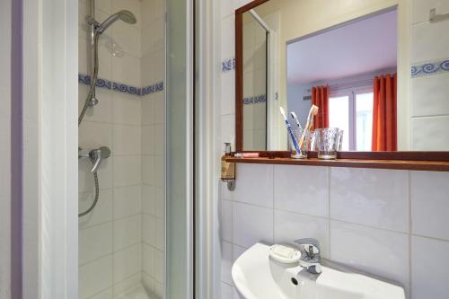 a bathroom with a sink and a shower and a mirror at Hôtel Viator in Paris
