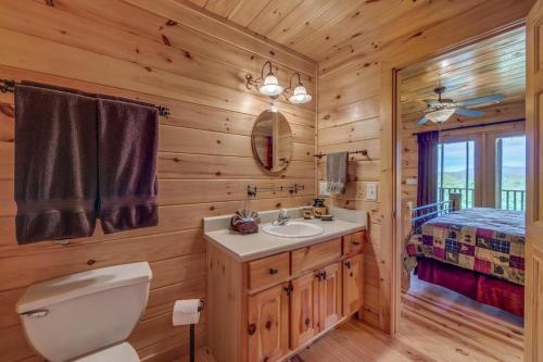 a bathroom with a sink and a toilet and a bed at Treetops Hot Tub Fire Pit Pool Table in Copperhill