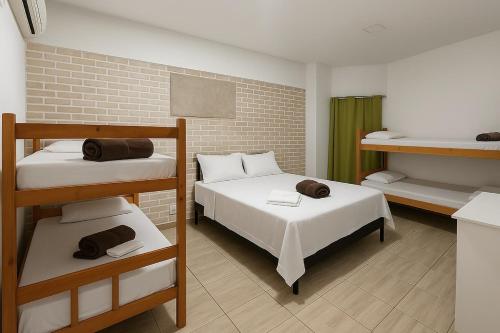 a room with two bunk beds and a bathroom at Pousada Luz do Sol in Penha