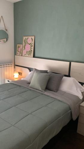 a bedroom with a large bed with a blue wall at El Relax, La Puebla De Castro in La Puebla de Castro