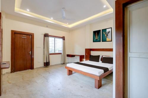 a bedroom with a bed and a window and a door at Hotel O Rajdhani Heritage in Nāmkom