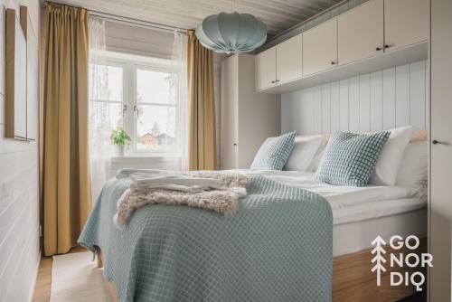 a bedroom with a bed with a green blanket on it at The Red Deer Lodge in Tällberg