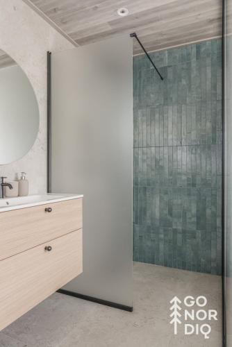 a bathroom with a shower and a sink and a mirror at The Red Deer Lodge in Tällberg