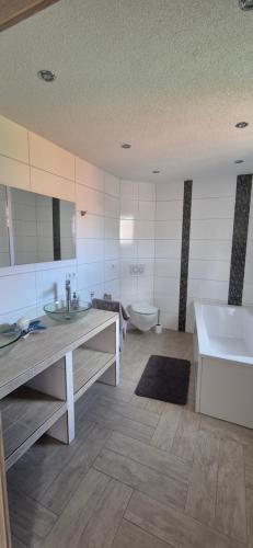a bathroom with two sinks and a tub and a toilet at Lindenplatz 6 in Sondershausen