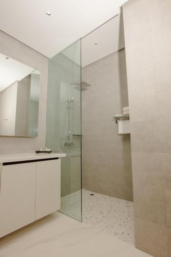 a bathroom with a glass shower and a sink at Atlantic Suites Hotel in Georgetown