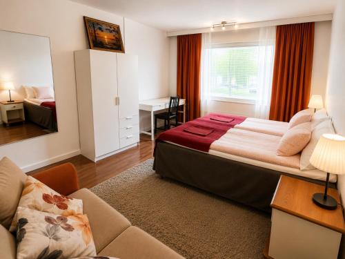 a hotel room with a bed and a desk at Rovaniemi City Apartments in Rovaniemi
