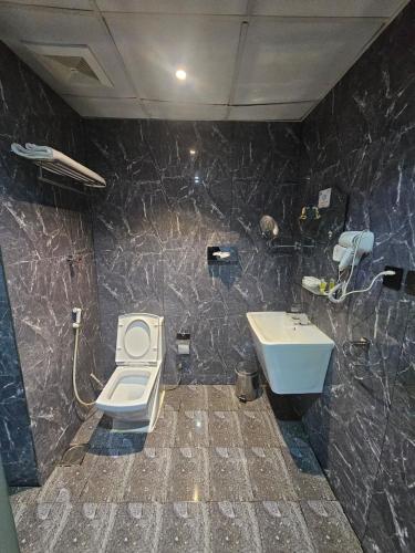 a bathroom with a toilet and a sink at فندق نواة العزيزية in Medina