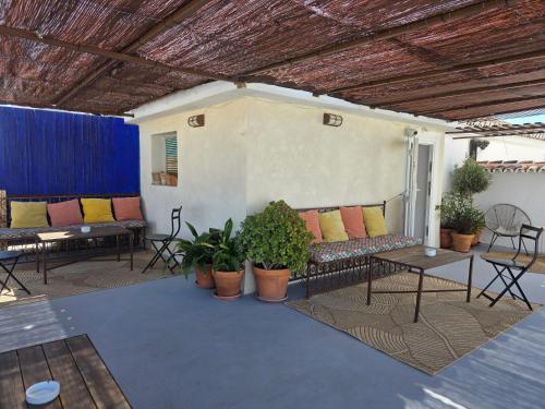 a patio with couches and tables and potted plants at Ronda Hotel Polo in Ronda