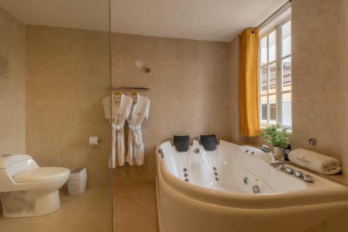a bathroom with a tub and a toilet and a sink at Hotel Serra Nova in Cajamarca