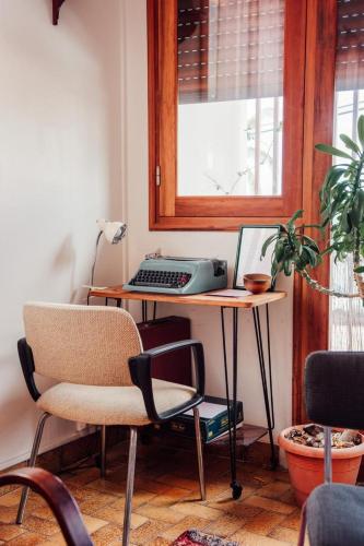 a desk with a computer and a chair in a room at La Maison du Marché in Saint-Pierre
