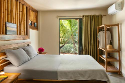 a bedroom with a bed and a sliding glass door at Hotel Café Con Leche in Playa Santana