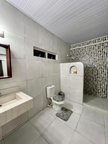 a white bathroom with a toilet and a sink at The Mountainstream Lodge in Lethem