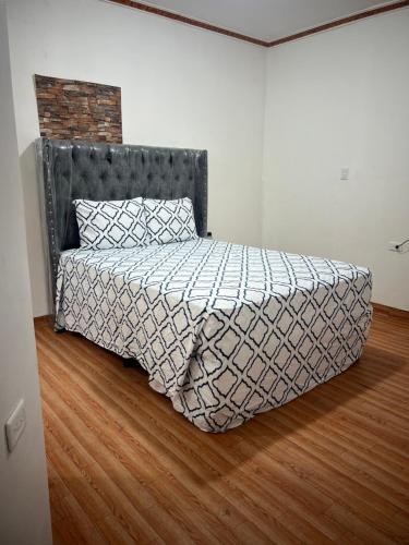 a bed in a room with a wooden floor at Hotel Atlántida in La Ceiba