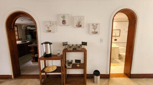a room with two arches and a mirror and a kitchen at Paisa Hostel Medellín in Medellín