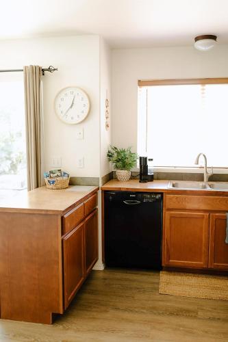 a kitchen with a black dishwasher and a clock on the wall at The Lighthouse in Moscow
