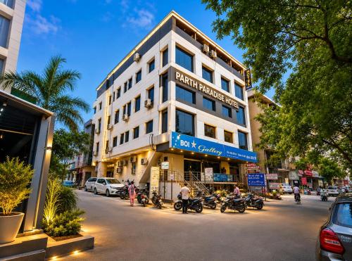 a building on a city street with motorcycles parked in front at Parth Paradise Hotel in Indore